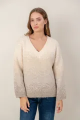 Sweater de punto con escote en V, diseño de mangas largas y efecto degradado que transiciona de un tono crema en la parte superior a un tono beige en la parte inferior.