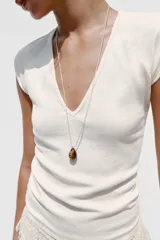 Camiseta color crudo de corte slim fit, con escote en pico, manga corta y tejido de punto acanalado.