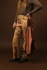 Pantalón de cuero beige de tiro alto y silueta recta con estampado artístico pintado a mano.