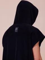 Poncho negro con capucha y logo de la marca Rusty estampado en blanco en el frente.