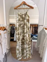 Vestido largo de modal con estampado floral en tonos blanco y negro, de silueta amplia y caída fluida, escote fruncido y tiras finas para atar al cuello. Cuenta con forro corto interno y tajo en la espalda.