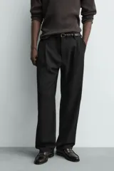 Pantalón straight fit color negro confeccionado en tejido con lana, con detalle de pliegues en el delantero, bolsillos frontales y traseros, y cierre frontal con cremallera y botón.