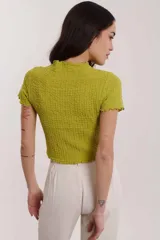 Blusa lavanda de mangas cortas con textura arrugada y cuello alto.