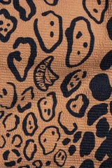 Conjunto de bikini de dos piezas con estampado animal print, compuesto por un corpiño triangular con tirantes finos regulables y bombacha con lazos ajustables a los laterales.