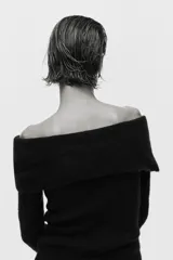 Buzo de punto acanalado con escote off-the-shoulder y detalle de nudo frontal. Presenta un diseño ajustado de manga larga y bajo recto.