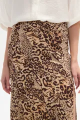 Falda larga de corte recto con abertura lateral pronunciada, confeccionada en tejido fluido con estampado abstracto en tonos tierra y crema.