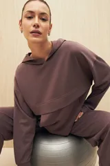 Canguro color beige de la línea Essence, con capucha, corte amplio y detalle de recorte frontal.