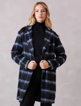 Tapado símil mohair, marca Dictionary, con estampado a cuadros en negro y azul. Tiene cuello con solapa, cierre frontal con botones y bolsillos delanteros. Incluye forro interno a tono.