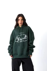 Hoodie de color verde oscuro confeccionado en friza, con capucha, cordones ajustables y bolsillo canguro. Presenta una estampa frontal blanca con el texto 'AnmeEdition' y 'CLUB' en un diseño ovalado de estilo desgastado.