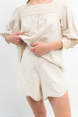 Short color crema con bordado calado, cintura alta y ruedo festoneado.