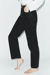 Jeans de tiro alto con corte mom fit, cinco bolsillos y cierre frontal con cremallera y botón metálico.