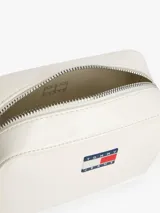 Cartera tipo bandolera de Tommy Jeans, color blanco con acabado brillante. Presenta cierre de cremallera, correa ajustable y la insignia distintiva de la marca en la parte frontal.
