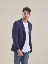 Blazer formal color negro, confeccionado en tela texturada, con solapas clásicas, cierre de dos botones frontales y bolsillos con solapa.