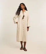 Vestido chemise recto, confeccionado en viscolino con 15% de lino, con cuello, abotonado delantero y mangas 7/8. Color beige claro.
