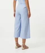 Pantalón pantacourt a rayas verticales azules y blancas, confeccionado en algodón. Incluye cinturón blanco con hebilla forrada.