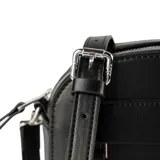 Bandolera de tamaño pequeño en color negro, confeccionada en material sintético con acabado liso. Presenta un diseño de silueta redondeada con cierre superior, correa ajustable y un aplique decorativo frontal con el logo de la marca.