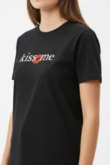Remera blanca de manga corta y cuello redondo, con corte holgado y estampado frontal que dice 'I <3 LA' con letras de animal print y un corazón rojo.