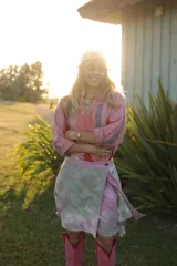 Minifalda de lino y algodón con estampado tie-dye en tonos rosados y verdes. Presenta cintura elastizada en la espalda, cinto decorativo y tablas laterales que aportan movimiento y volumen.