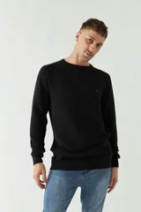 Sweater negro de punto con textura acanalada horizontal, cuello redondo y logo bordado en el pecho.