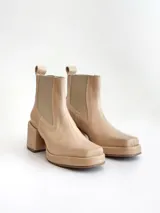 Botas tipo chelsea de cuero color visón, con plataforma, taco cuadrado y punta cuadrada.