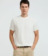 Remera masculina blanca de corte regular, con cuello redondo, manga corta y textura vertical. Confeccionada en poliéster y algodón.