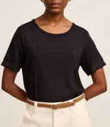 Blusa de cuello redondo y manga corta, confeccionada en tejido de viscosa con elastano. Presenta costuras vistas y pespuntes en contraste que recorren el frente de la prenda.