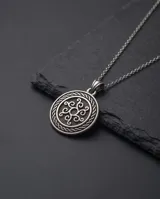 Dije de acero circular con diseño grabado de estilo vikingo.