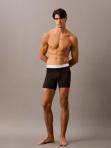 Pack de tres calzoncillos tipo boxer brief Calvin Klein, confeccionados en mezcla de algodón elástico. Diseño de talle medio con cinturilla elástica distintiva de la marca en colores azul, celeste y salmón.