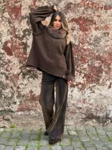 Sweater de punto color marrón chocolate, con cuello alto de piel sintética y mangas largas con detalles de costuras desflecadas. Diseño holgado con puños tejidos.