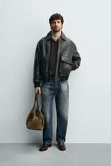 Cazadora relaxed fit de piel color marrón oscuro, con cuello solapa, manga larga y dos bolsillos plastrón con solapa en la cadera. Presenta detalle de bolsillo interior, efecto lavado y acabados en rib. El cierre frontal es con cremallera oculta por solapa con botones a presión.