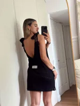 Vestido corto tejido en algodón y lurex, color verde oliva con destellos brillantes. Presenta escote pronunciado en la espalda, breteles con terminación en borlas y diseño calado.