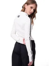 Remera de manga larga blanca con cuello alto, corte ceñido al cuerpo y franja vertical negra de contraste a lo largo de las mangas.
