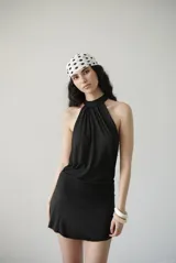 Minivestido negro de algodón con cuello halter y espalda descubierta. Se ata detrás del cuello y tiene una faja en la cintura.