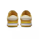 Championes Nike Dunk Low Twist en tonos amarillo y crema. Presentan un diseño deconstruido con swoosh flotante, refuerzos en la puntera y el talón, y una suela de goma en color amarillo vibrante.