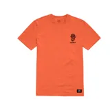 Remera naranja de manga corta con cuello redondo y estampado pequeño de calavera con gorro y barba en el pecho. Logo de Etnies debajo del estampado.