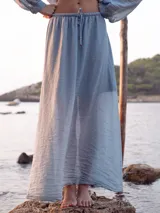 Falda larga hasta el tobillo de tejido liviano con acabado arrugado, corte fluido y cintura elástica con cordón ajustable.