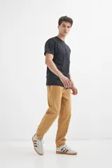 Pantalón de gabardina color ocre, con corte recto, cintura elastizada con cordón ajustable y bolsillos laterales.