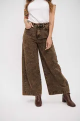 Pantalón de jean de corte wide leg con efecto de lavado ácido en tono marrón. Presenta tiro alto, cierre frontal con botón y bolsillos laterales.