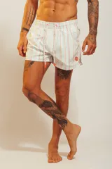 Short de baño rosado con estampado tropical de palmeras y vehículos, con cintura elástica con cordón ajustable.