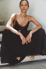 Vestido largo de tirantes finos con escote en pico, cuerpo con frunces elásticos y detalle de encaje a tono en la parte superior. Cuenta con forro interior y falda fluida.