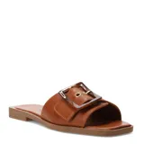 Sandalias planas de cuero marrón, tipo slide, con una tira ancha en el empeine adornada con una hebilla grande con efecto carey y ojal metálico dorado.