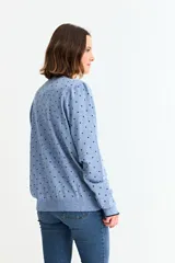 Sweater de manga larga, color negro, con cuello redondo y estampado de pequeños corazones dorados distribuidos por toda la prenda.