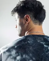 Remera negra con efecto tie-dye y logo pequeño en el centro del pecho.