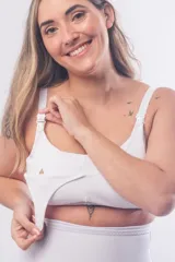 Soutien maternal sin aro, color blanco, diseñado con doble clip en los breteles para facilitar la lactancia y el uso de extractor. Presenta un escote alto, breteles elásticos regulables y cierre de broches en la espalda.