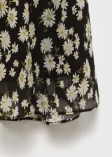 Falda midi de gasa color negro con estampado de pequeñas flores blancas.
