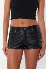 Short negro de cuerina, tiro medio, con bolsillos delanteros y traseros, presillas en la cintura y cierre con botón metálico y cremallera.