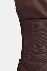 Vestido midi de escote recto sin tirantes, color marrón, con diseño semitransparente en la sección del abdomen y detalle drapeado en la falda. Cuenta con cierre lateral.