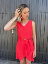Conjunto de dos piezas color rojo, compuesto por un top sin mangas con escote en V y una falda corta cruzada con lazo ajustable a la cintura.