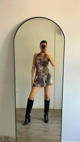 Minivestido marrón con estampado abstracto en tonos marrones y blancos, escote halter y falda con volantes.