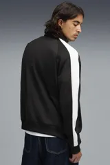 Campera Puma modelo T7 Track Jacket 692462, de color beige con franjas blancas en las mangas y cuello alto. Cuenta con cierre frontal completo y bolsillos laterales.